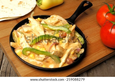 Creamy chicken and green pepper fajita toppings in a skillet
