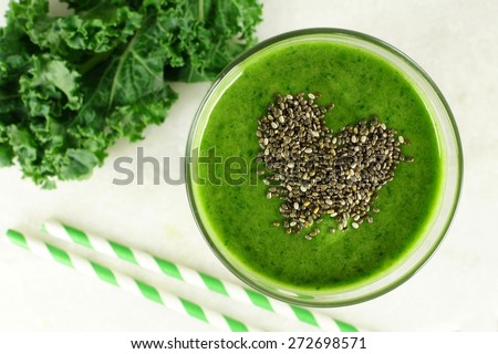 Green kale smoothie downward view in glass with heart shape made of healthy chia seeds