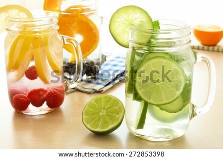 Detox water with various types of fruit in mason jars on a table