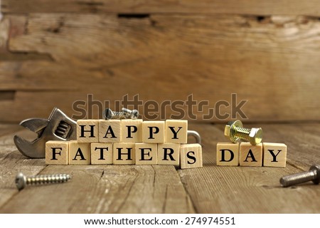 Happy Fathers Day blocks with tools on a rustic wood background