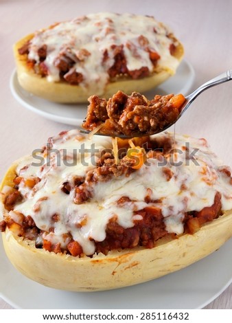 Fork full of spaghetti squash baked with lean ground turkey, peppers, tomato sauce and melted mozzarella cheese
