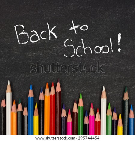 Bottom border of colorful pencil crayons against a blackboard with Back to School writing in chalk