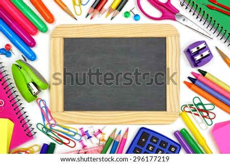 Blank chalkboard on a white background with school supplies surrounding