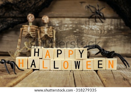 Happy Halloween wooden blocks with spiders, skeletons and old wood background