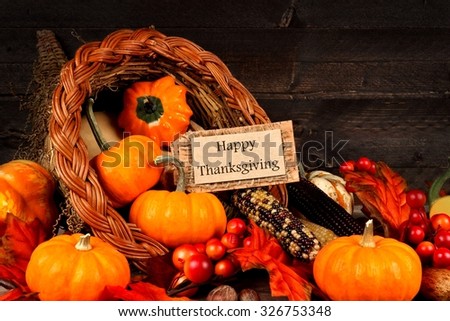 Harvest cornucopia close up with Happy Thanksgiving gift tag on dark wood background