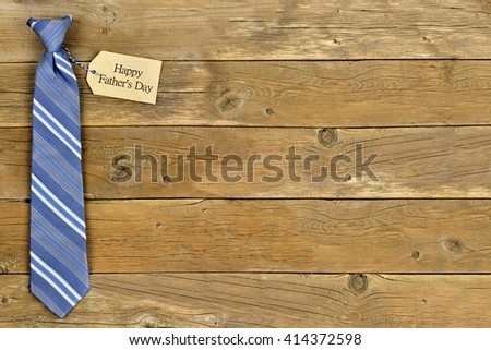 Happy Fathers Day gift tag with blue striped necktie on rustic wood background