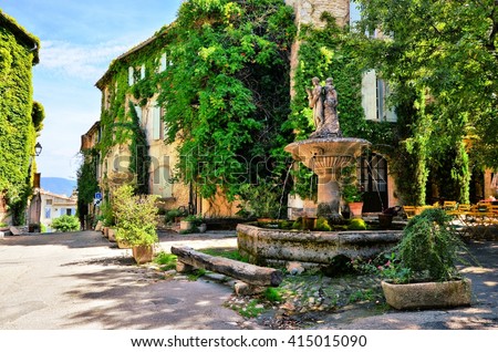Leafy town square with fountain in a picturesque village in Provence, France