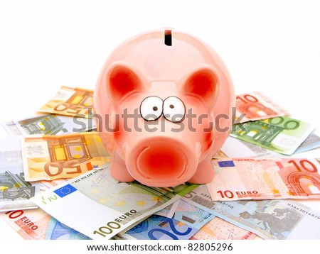 Face view of a piggy bank standing among a group of scattered Euro notes