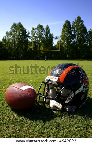Football and helmet with goal post in background