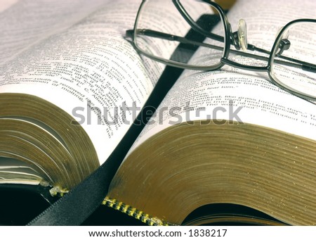 an open bible with reading glasses