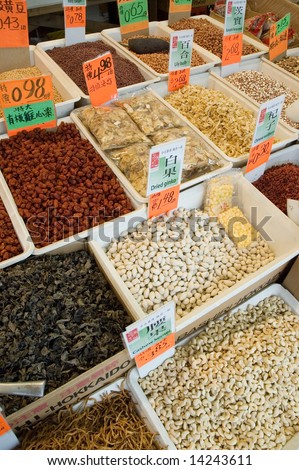 dried fish, nuts, fruit, seeds, and mushrooms displayed in bins on the sidewalk outside a store in Chinatown, Vancouver, British Columbia, Canada