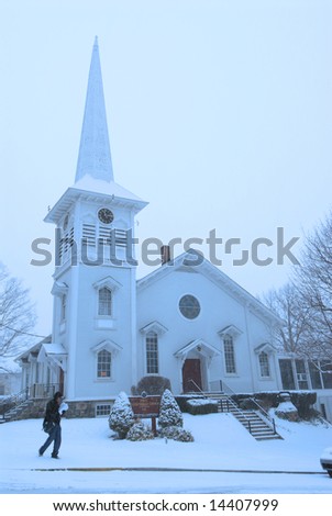 a postal worker walks past a Presbyterian Church during a snowstorm at twilight-Boonton New Jersey