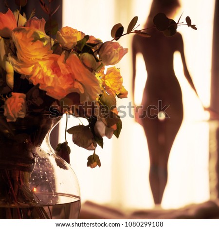 Lifestyle art photo of beautiful sensual blonde with flowers at the window. Home interior. Beautiful morning. Aroma bouquet. Perfume