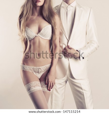 Art photo of a young couple in sensual lingerie and a tuxedo