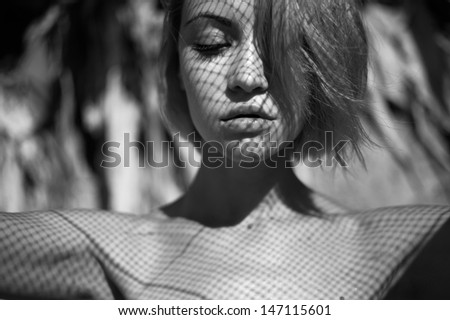 Beautiful young lady with a delicate fishnet pattern on face