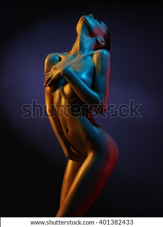 fashion art photo of elegant nude model in the light colored spotlights