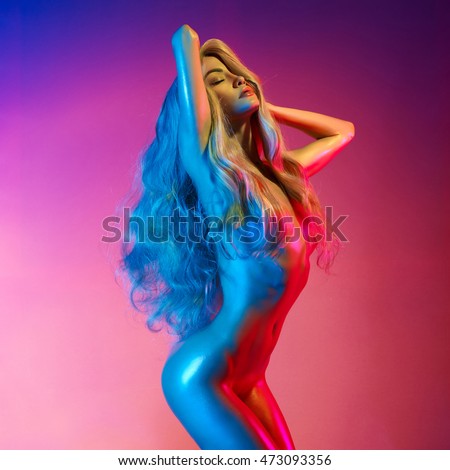 Nude beautiful blonde dancing  in colorful light. Erotic portrait of sexy woman with long hairs.