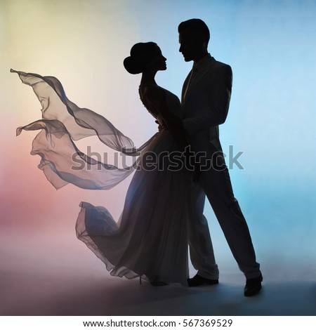 Art fashion studio photo of wedding couple silhouette groom and bride on colors background. Art Wedding style. Flowing dress. Dance of groom and bride