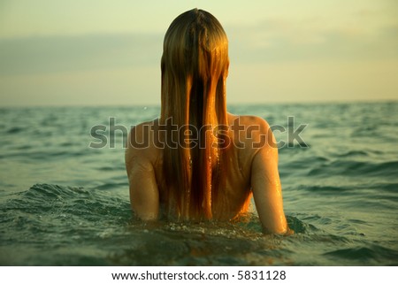 The girl swiming in sea waves. An art photo. A beautiful landscape.