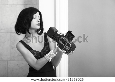 Fashion portrait of young photographing lady. Black and white photo