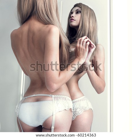 stock photo Nude girl in beautiful underwear in front of the mirror