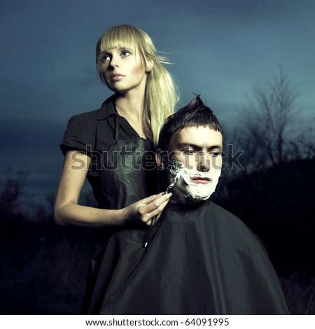Beautiful woman barber shaves a courageous man. Surreal picture