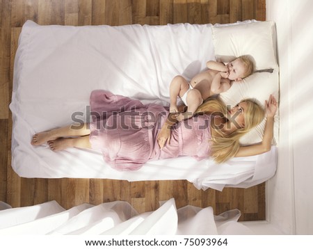 Photos of a beautiful young mother with a naked child in bed Photos of a beautiful young mother with a naked child in bed