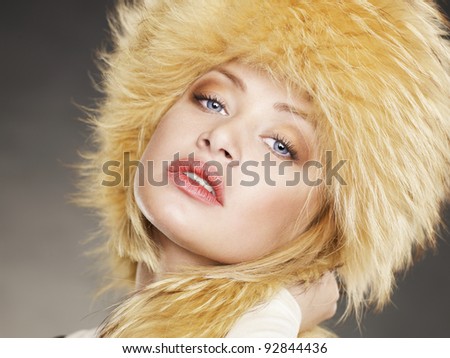 Fashion photo of beautiful young woman in a fur hat