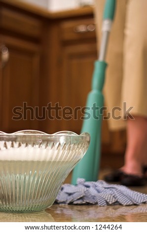 Wrong tool for the job: Young woman using a crystal punch bowl as a mop bucket.