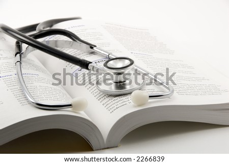 stethoscope on open book on a white background