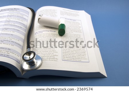medical learning book stethescope and a inhaler on blue background