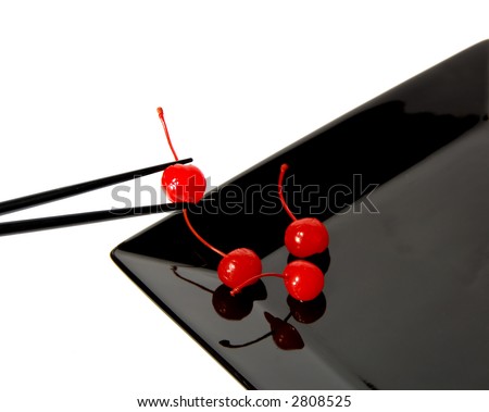maraschino cherries on a black plate eating with chopsticks