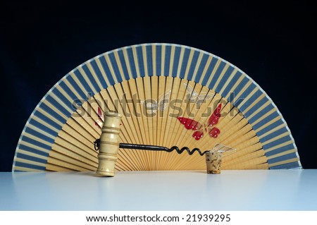 old ivory corkscrew with Oriental fan on black background