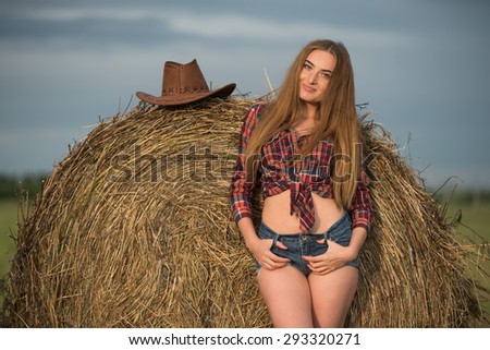 Happy woman in the field in cowboy style