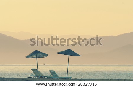 Romantic photo of Double sunshade on a beach without people in the morning