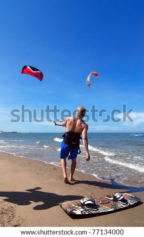 Kite-boarder surfing in the blue sea over the blue sky