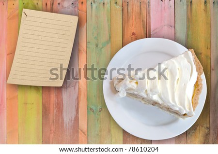banana cream custard pie on colorful wooden table with note