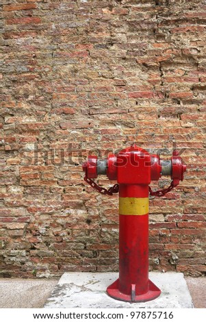 Red fire hydrant with old brick wall background