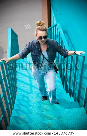 Cool girl climbs the ladder of turquoise color
