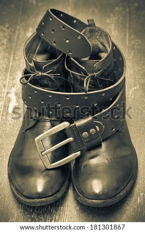 Expensive leather footwear and leather strap with buckle.. vintage style. cowboy style