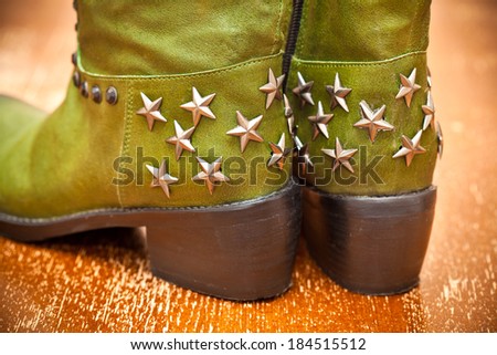 Green women\'s boots with asterisks in cowboy style on vintage background