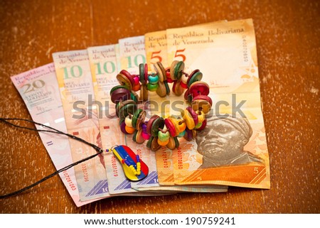 The national currency of Venezuela, Latin America. Colorful handmade bracelet; souvenir - a pendant in the form of the flag of Venezuela.