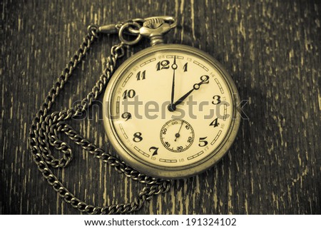 Vintage watch with chain on vintage background