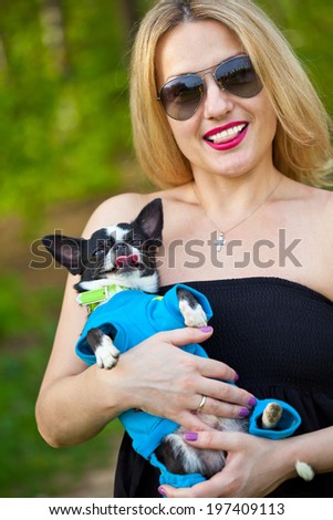 Beautiful woman with chihuahua dog sticks out his tongue and smiling