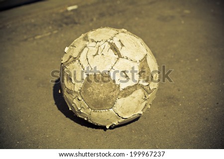 old soccer ball outdoors. photo toned yellow