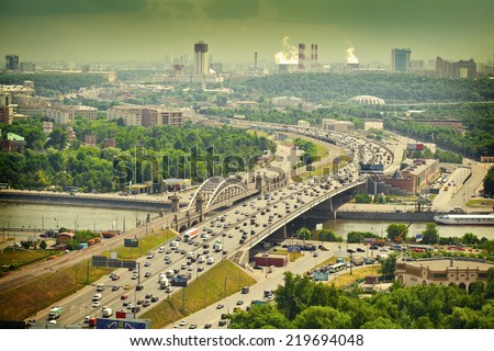 Moscow - city landscape. Road with cars at rush hour. The Third Ring Road. Life of the big city. Moscow river. City Attractions. Photo toned in yellow