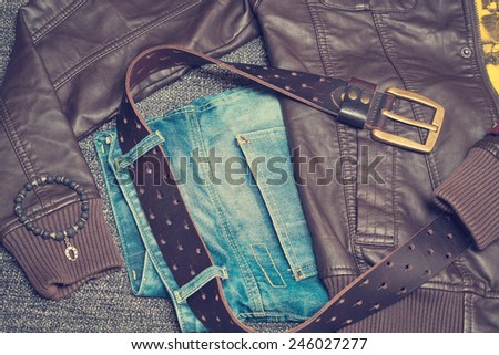 Urban fashion clothing: jeans with a belt, jacket, bracelet. Vintage style