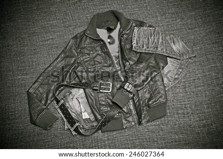 Fashion: Leather jacket, jeans with a belt, shirt, watches, note 5 euros. Retro style, black-and-white photo