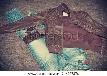 Fashion style: leather jacket, blue jeans, a leather belt with a buckle. Youth urban clothing. Vintage style