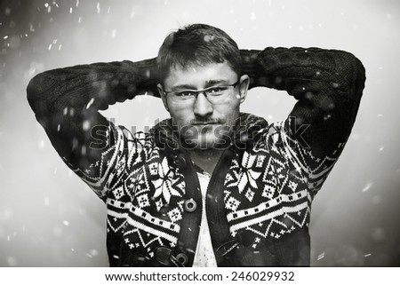 young man in a winter sweater, falling snow flakes